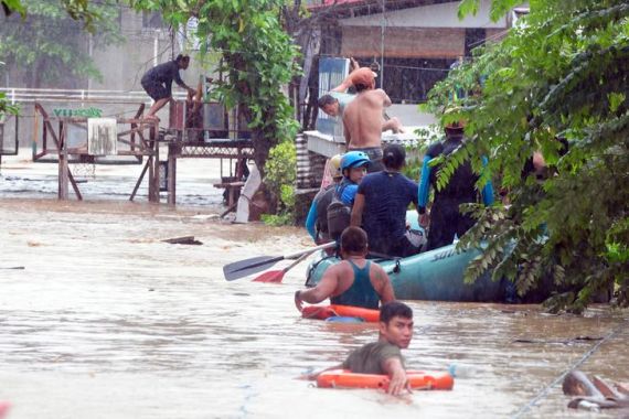 Rescuers evacuate residents from their homes during heavy flooding in Cagayan de Oro city in the Philippines