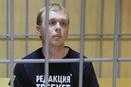 Ruski istraživački novinar Ivan Golunov, koji je zadržan u pritvoru i optužen za prekršaje u vezi droge, sjedi unutar ograđene kabine tokom sudskog saslušanja u Moskvi 8. juna (Reuters)