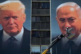 Radnik stoji na dizalici dok postavlja plakat na kojem su američki predsjednik Donald Trump i izraelski premijer Benjamin Netanyahu, u Jerusalemu 10. juna 2020. (Reuters)