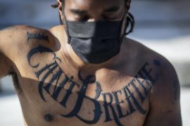 Demonstrant, sa tetovažom na prsima na kojoj piše 'Ne mogu disati' poštuje trenutak šutnje na demonstracijama na praznik Juneteenth, 19. juna 2020. u SAD-u. (AP)