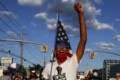 Demonstrant predvodi i uzvikuje povike tokom marša pokreta Black Lives Matter (AP)