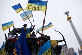 Demonstranti stoje na kipu sa ukrajinskim zastavama tokom skupa protiv predsjednika Viktora Janukoviča na Trgu nezavisnosti u Kijevu, 15. decembra 2013. [Reuters/Marco Djurica]