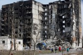 Lokalni stanovnici u blizini stambene zgrade u Mariupolju uništene tokom ruske invazije (Reuters)