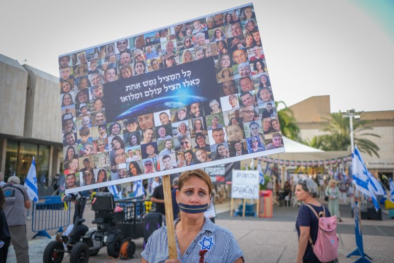 Žena drži plakat na demonstracijama u Tel Avivu pozivajući na oslobađanje taoca koje drži Hamas u Gazi (Al Jazeera)