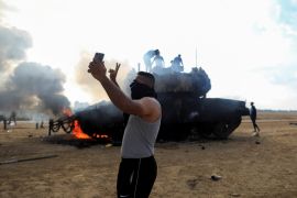 Reuters je objavio fotografiju Palestinaca sa zapaljenim oklopnim vozilom izraelske vojske (Reuters)