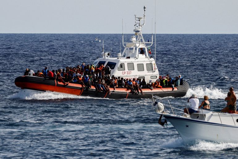 Brod italijanske obalne straže sa migrantima spašenim na moru prolazi pored turističkog broda, na sicilijanskom ostrvu Lampeduza, Italija, 18. septembra 2023. (REUTERS/Yara Nardi)