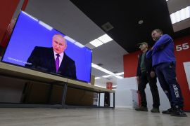 Ljudi prate televizijski prijenos godi&scaron;njeg obraćanja ruskog predsjednika Vladimira Putina (Alexey Pavlishak / Reuters)