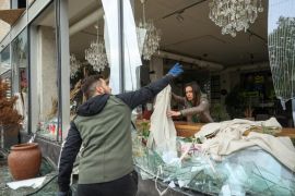 Ukrajinci uklanjaju krhotine stakla sa razbijenih prozora prodavnice o&scaron;tećene u ruskom napadu na Harkov [Sofiia Gatilova / Reuters]